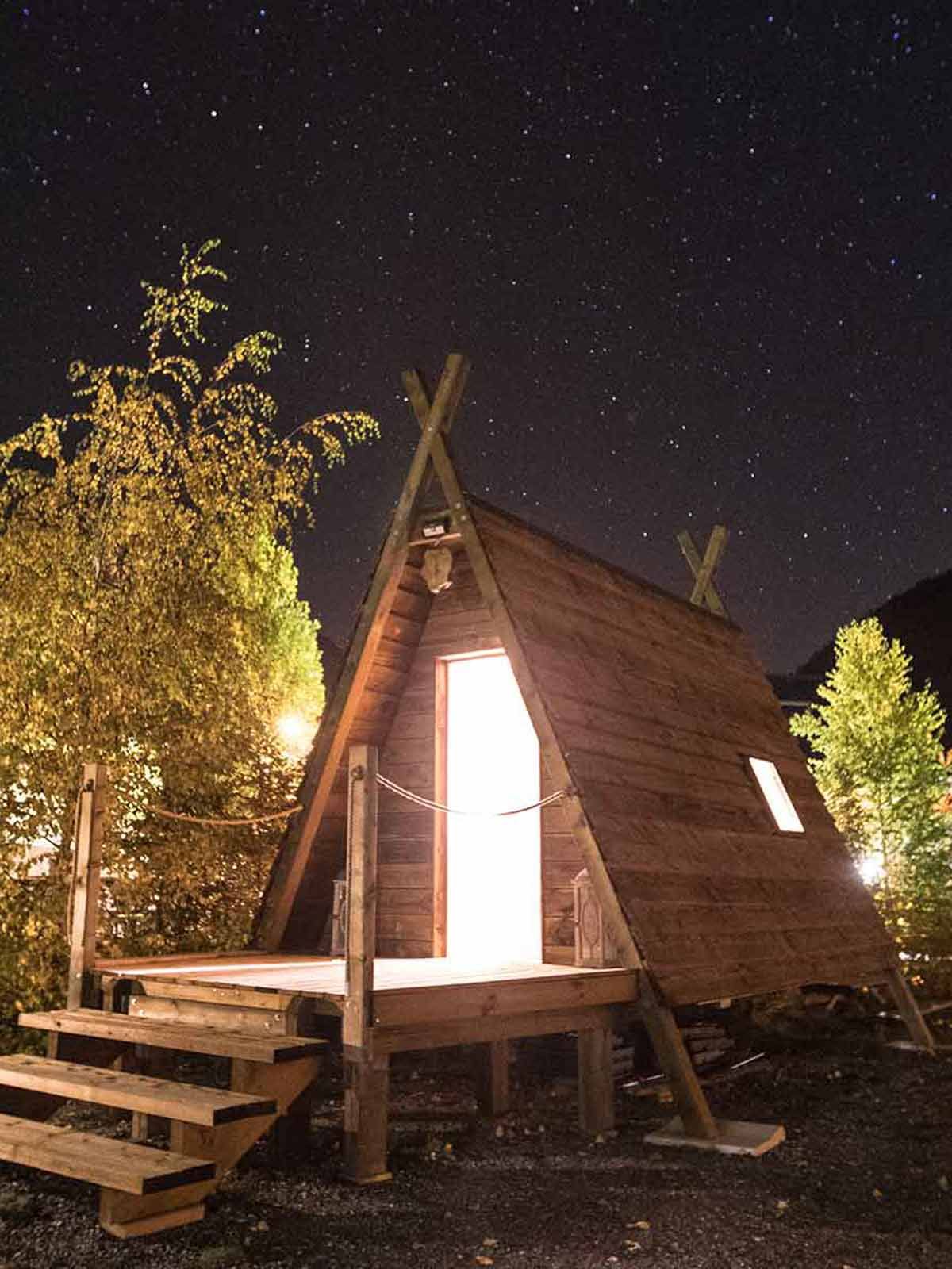 La Cabadienne en bois éclairée sous un ciel étoilé