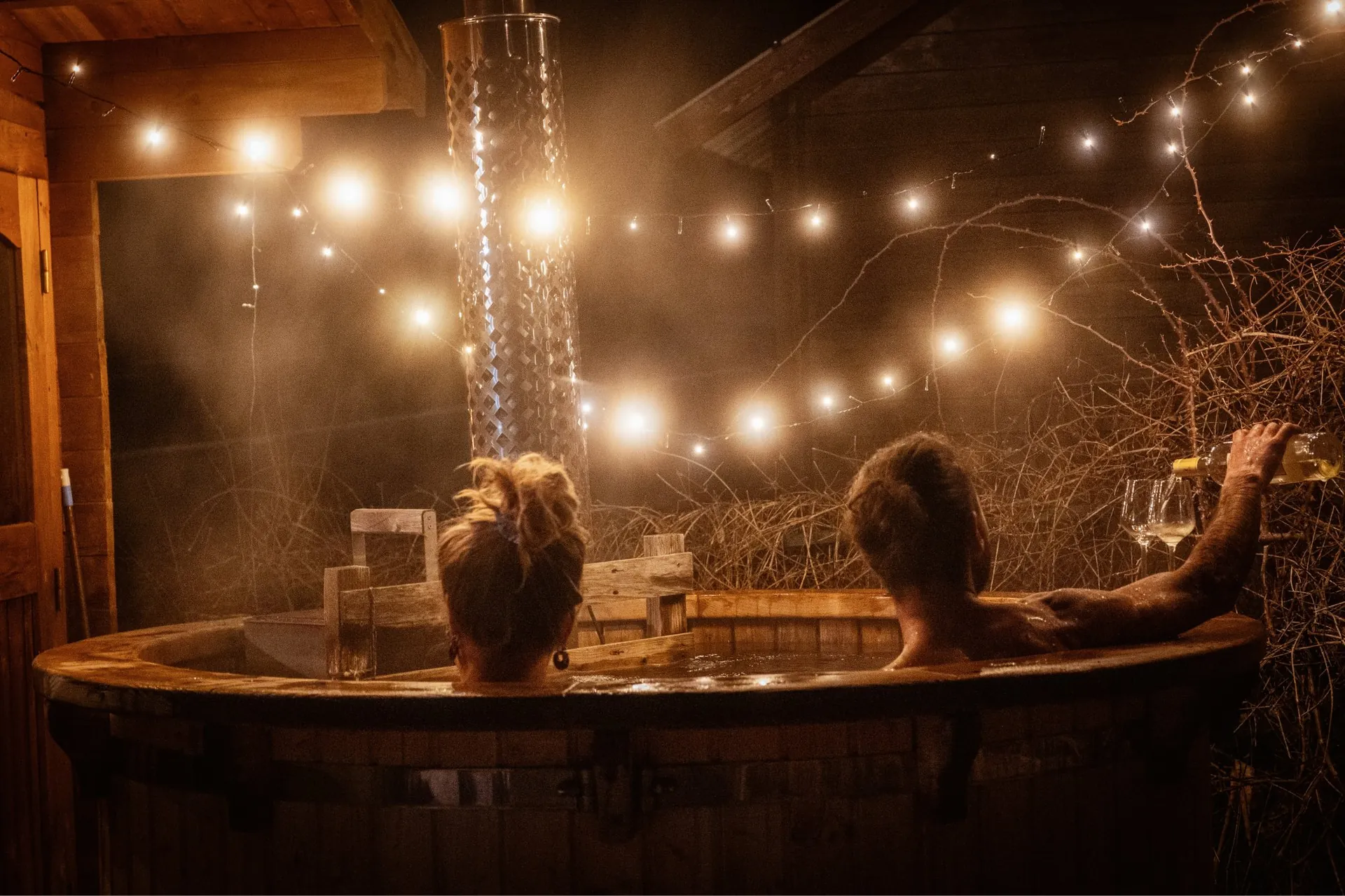 Bain nordique à 38 °C le soir sous les guirlandes lumineuses